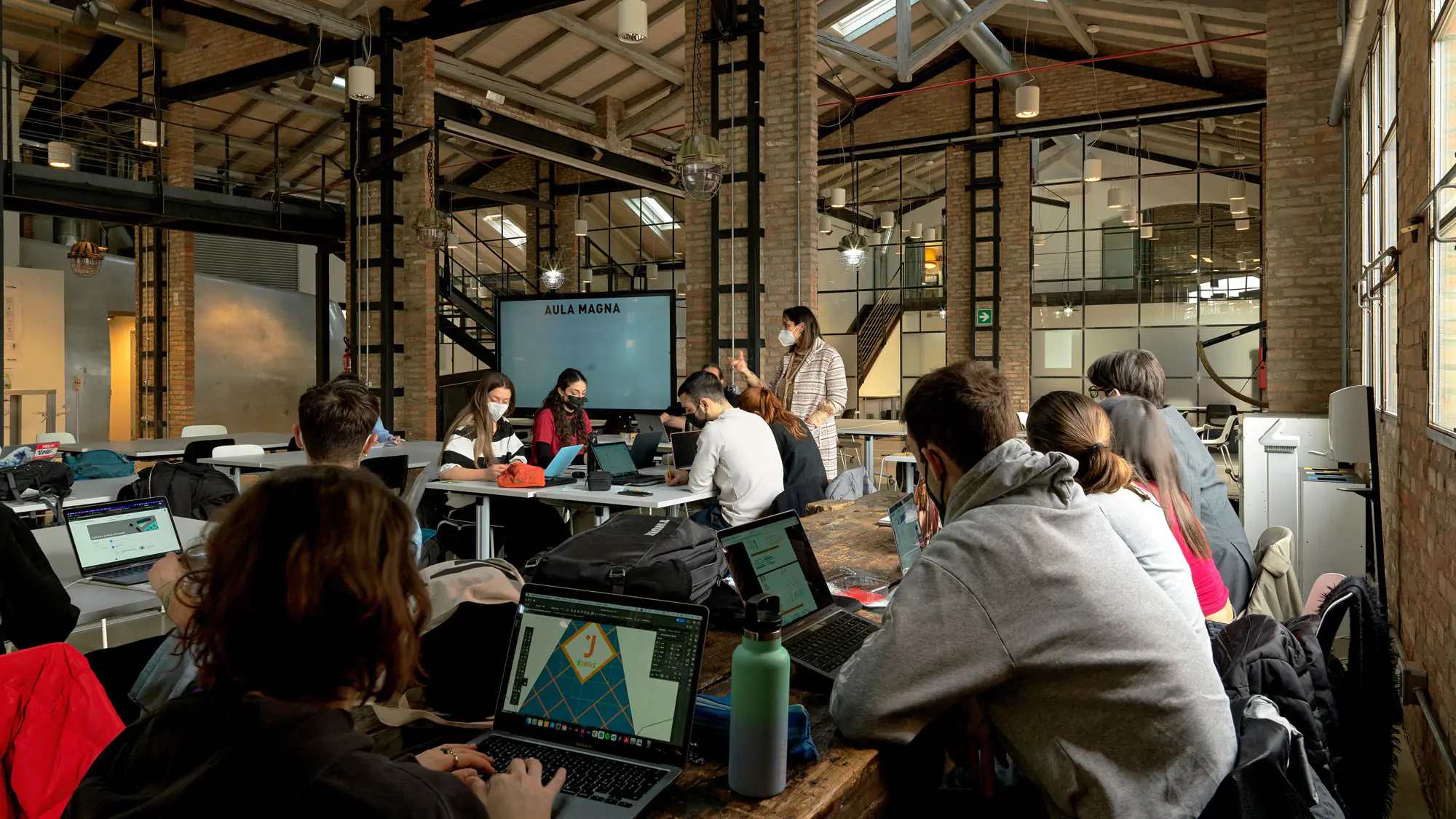 Una docente spiega una lezione del corso in Communication design nell'Aula Magna di IAAD. Bologna