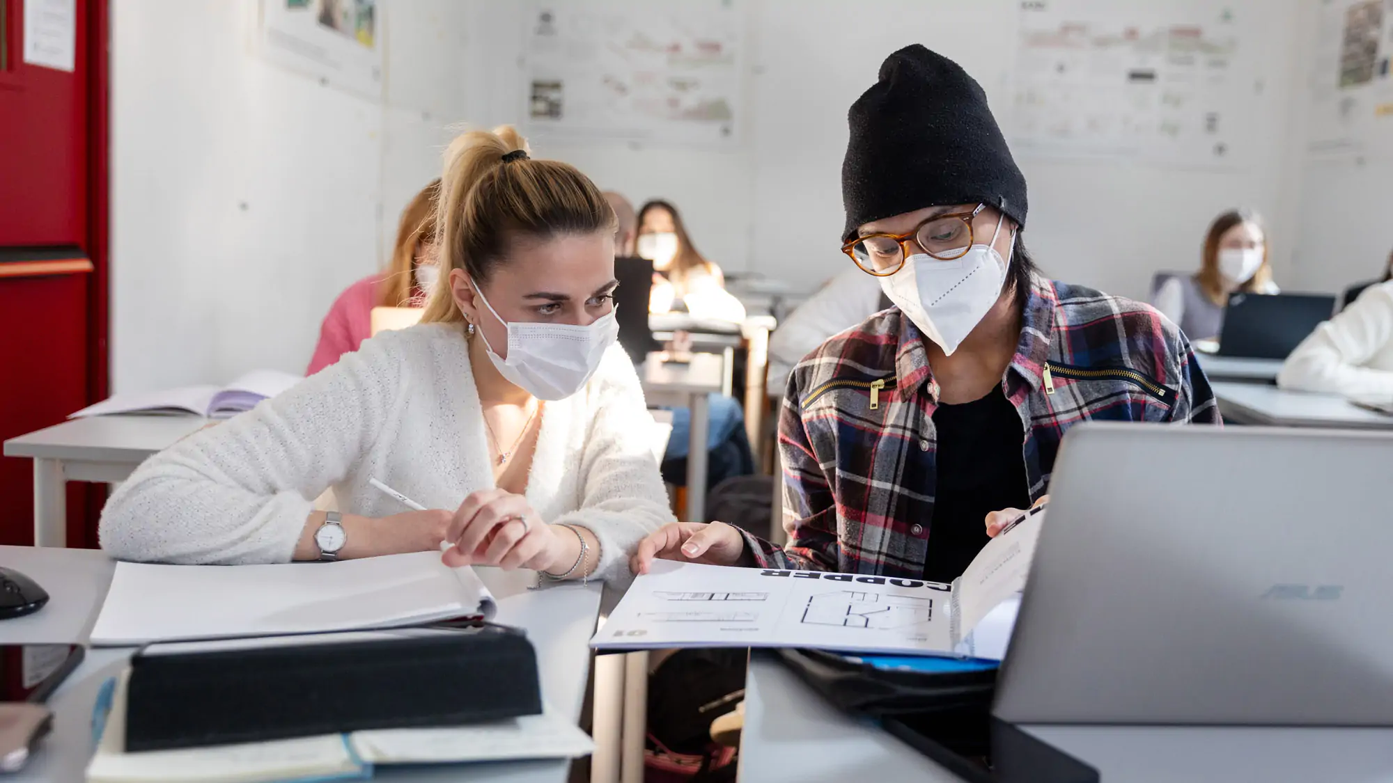 Two students wearing face masks in an Interior design classroom at IAAD University