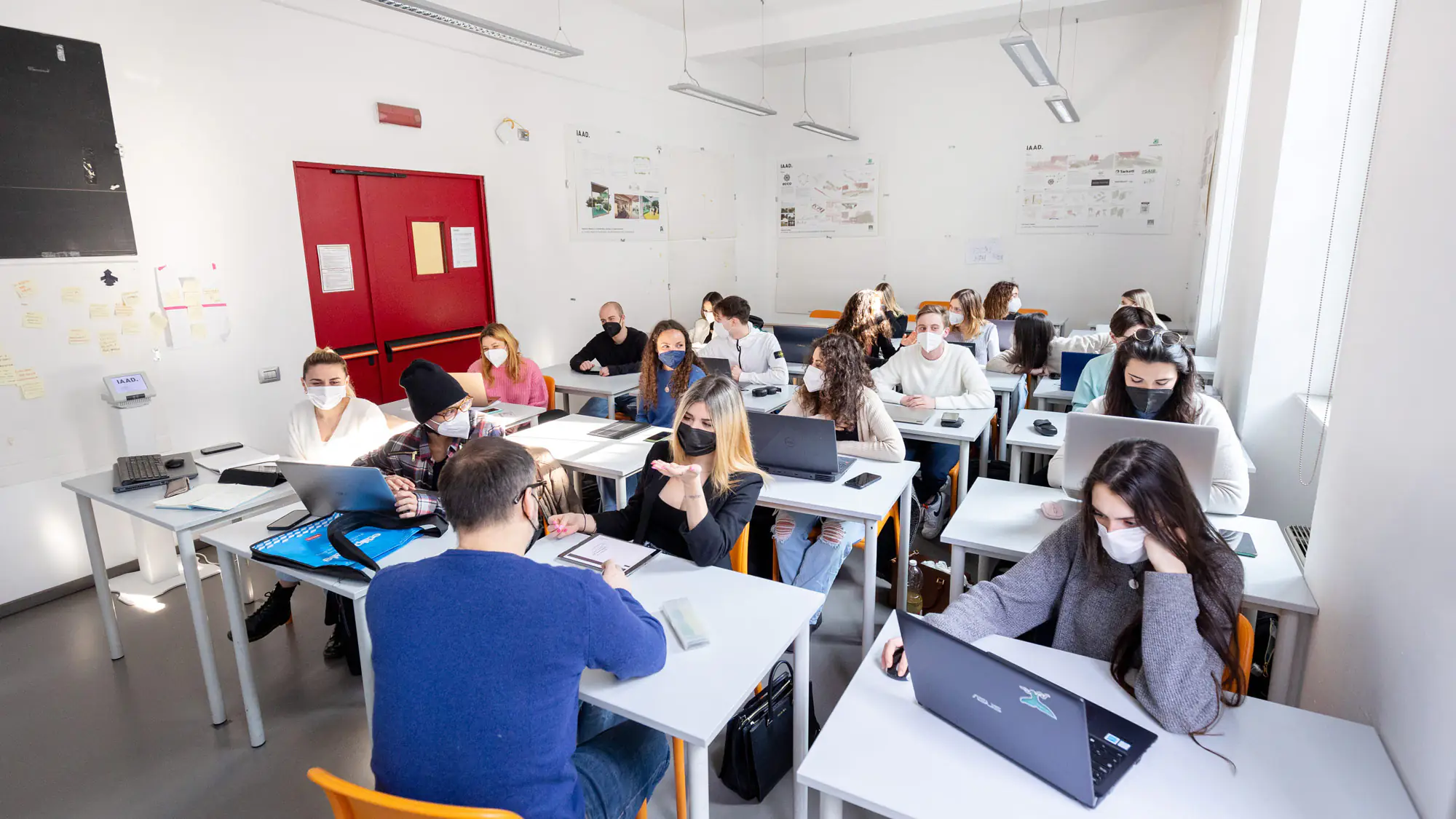 A classroom at IAAD university, students focused on laptops, engaged in learning activities during an Interior design lesson