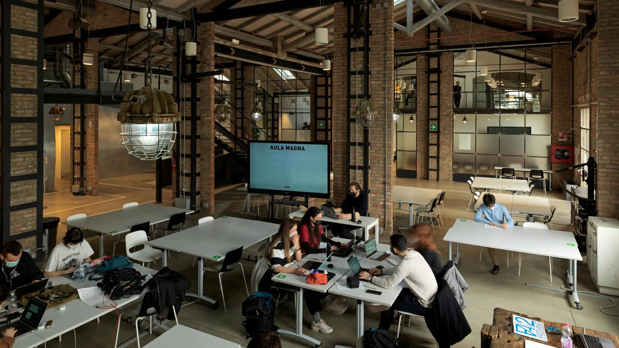 A study room on the IAAD. Bologna campus with some students sitting at a desk